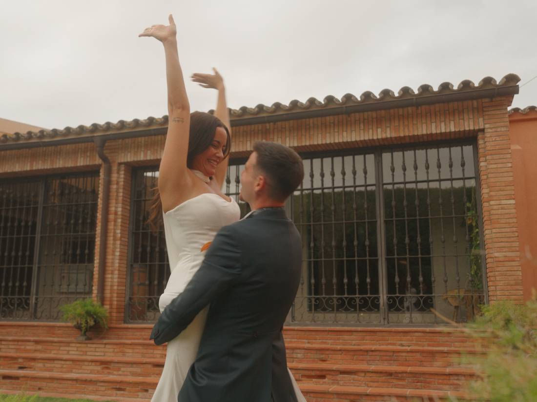 La novia, levantada en brazos, con los brazos en alto