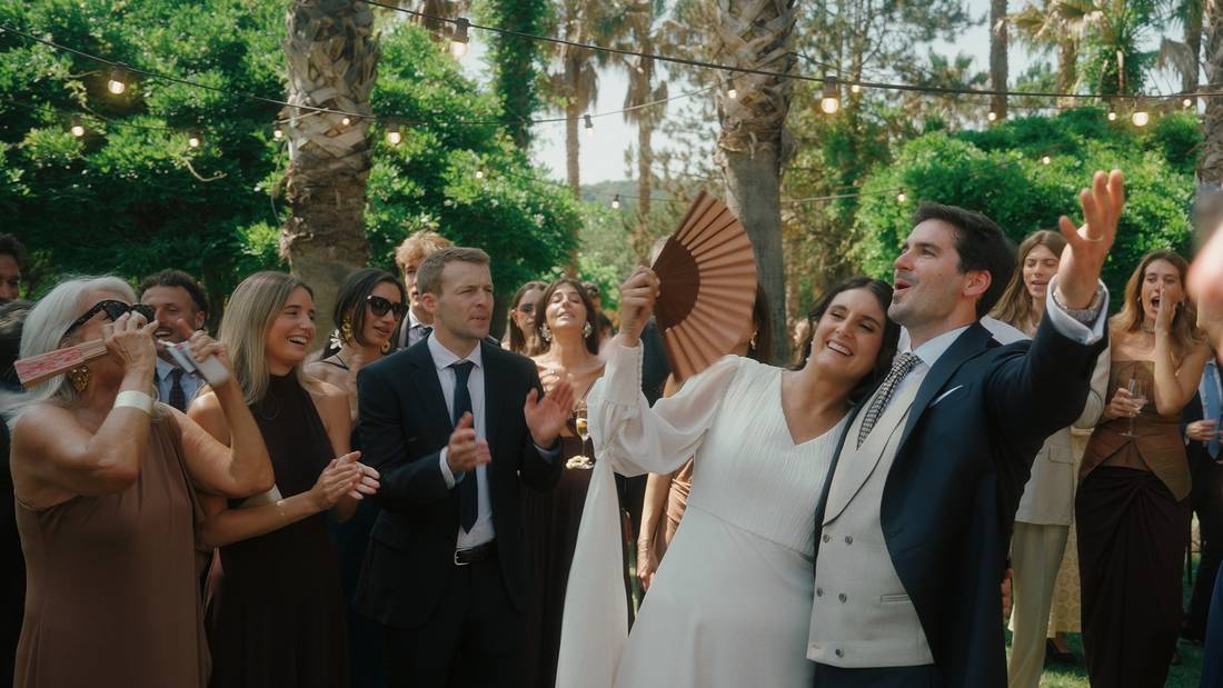Los novios bailan rodeados de invitados con abanicos